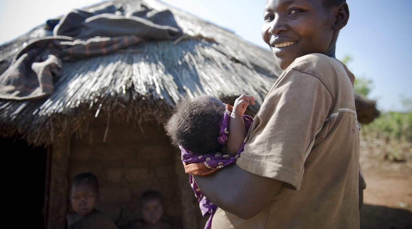 Nord Uganda. Donna con bambino davanti alla capanna di un villaggio. Ph Emanuela Colombo