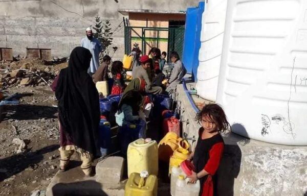 A group of people assisted by Cesvi is collecting water from a collection point rehabilitated through the USAID funded project.